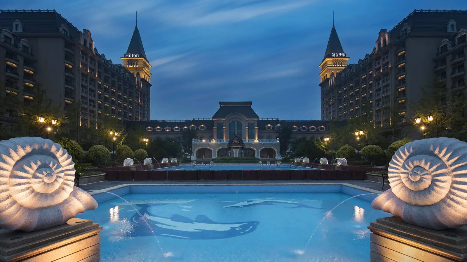 Outdoor pool and hotel setting at Hilton Qingdao Golden Beach